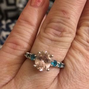 Pink ice encircled in blue gems silver toned band